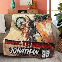 there is a motorcycle blanket on the couch in this living room, it says dare to ridein'jonathan