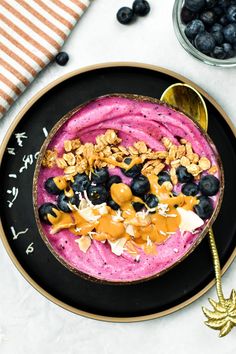 a bowl filled with blueberries and yogurt on top of a black plate