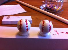 two baseballs sitting on top of a box next to a pencil and eraser