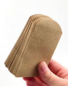 a hand holding a stack of brown paper