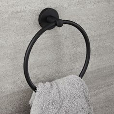 a close up of a towel holder on a wall with a black handle and a white towel