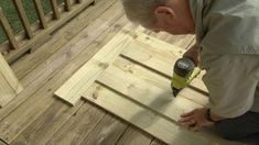 a man sanding wood on top of a wooden deck with a drill and screwdriver