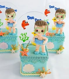 there are three little figurines on top of the cake, and one is holding a starfish