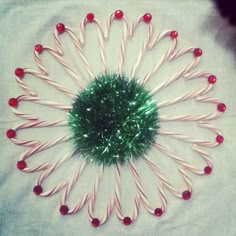 a green and red christmas decoration on top of a white table cloth with candy canes