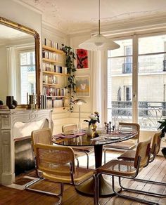 a dining room table with chairs and a fire place in the corner next to a fireplace