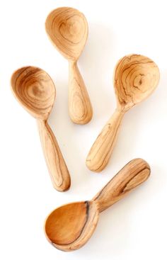 three wooden spoons and two wood spatulas on a white background