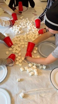 two children are playing with marshmallows on the table