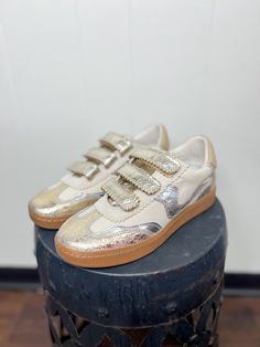 Step up your sneaker game with these trendy velcro gold kicks! Cute, comfy, and totally on point—perfect for adding a little sparkle to any outfit. Key Features: Distressed metallic leather and nylon upper Adjustable hook and loop triple strap closure Velcro Recycled textile lining Synthetic sock Recycled synthetic outsole Approx. 1" heel height