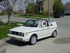 a white convertible car parked in front of a house