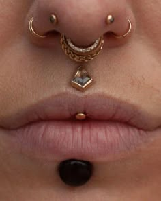 a woman's nose with two piercings attached to her nose and an ear ring