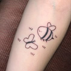 a small tattoo on the arm of a person with a bee and honeybees