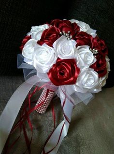 a bridal bouquet with red and white flowers on the back of a couch in a room