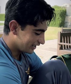 a man sitting on a bench looking at his cell phone