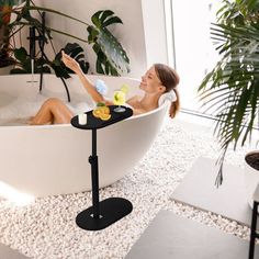 a woman sitting in a bathtub with a towel on her head and two yellow rubber ducks