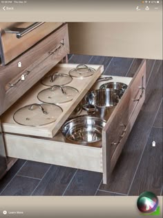 an open drawer with pots and pans in it