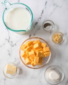 ingredients to make cheesecake on a marble countertop with milk, butter and eggs