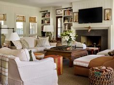 a living room filled with furniture and a flat screen tv mounted on the wall above a fire place