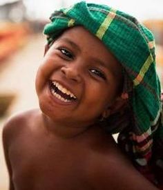 a young boy wearing a green hat and smiling