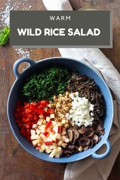 the ingredients for wild rice salad in a blue bowl on a wooden table with text overlay