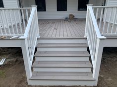 a white porch with steps leading up to the front door