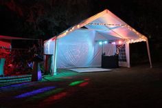 a white tent with lights on it at night