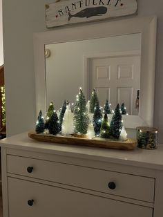 a white dresser with christmas trees on it