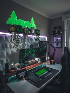 a desk with a computer monitor, keyboard and speakers on it in front of a window