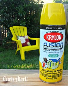 a yellow spray paint sitting on top of a wooden deck next to a chair and table