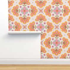 an orange and pink flowered wallpaper with a white shelf in front of it