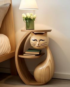 a cat shaped shelf next to a bed with a lamp on top of it and a flower pot in the corner