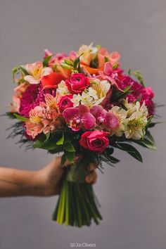 a person holding a bouquet of flowers in their hand