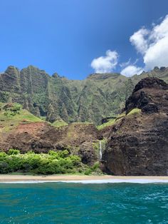 the ocean is blue and green with mountains in the background