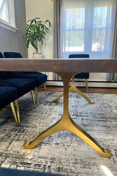 a dining room table with blue velvet chairs