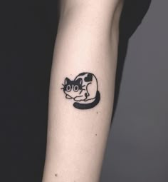 a black and white cat tattoo on the arm