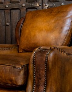 a brown leather reclining chair with nail polishing on the armrests and foot rest