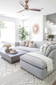 a living room filled with furniture and a ceiling fan