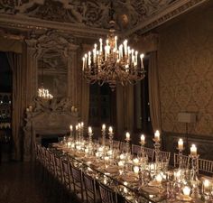 a long table is set with candles and place settings for dinner guests to sit at