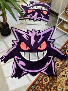 two rugs with an angry cat design on one and a plant in the other