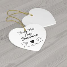 two white ceramic heart shaped ornaments with the words crazy cat lady sammatha on them