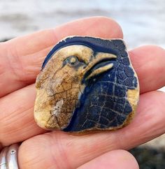 a hand holding a rock with an elephant's head on it