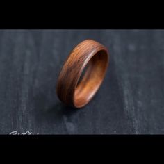 a wooden ring sitting on top of a black table next to a piece of wood