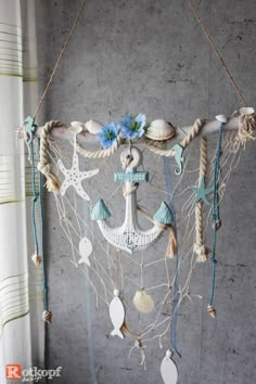 an anchor, starfish and seashells are hanging from a rope on the wall