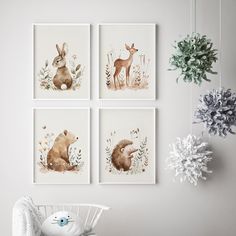 four framed pictures hang on the wall above a crib with a stuffed animal in it