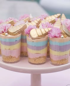 small desserts with pink flowers and gold decorations on a cake stand at a party