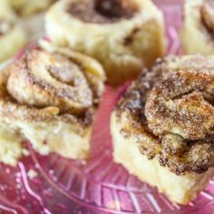 cinnamon rolls on a pink plate with powdered sugar