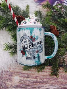 a blue and white coffee mug sitting on top of a table next to christmas decorations