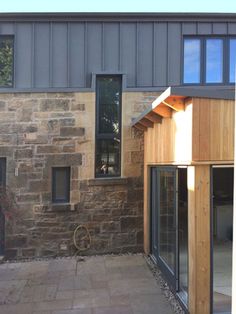 an outside view of a house that is made out of stone and has wooden trim