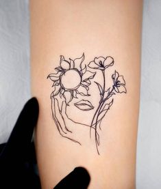 a woman's face with flowers on her arm