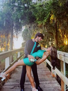 a man and woman kissing on a bridge