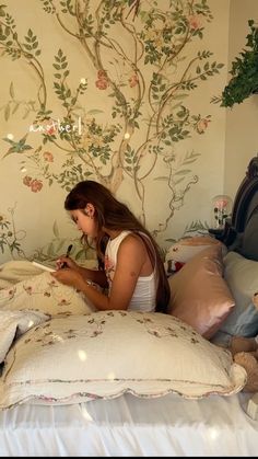 a woman sitting on top of a bed next to a teddy bear